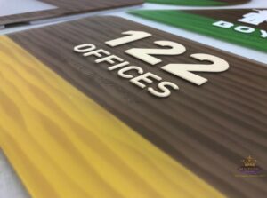 Room 122 offices sign with raised numbers, tactile lettering, and braille
