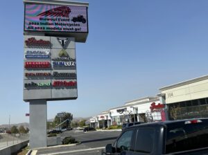 Multi-tenant pylon sign with tenant panels and digital message display at a Southern California retail property