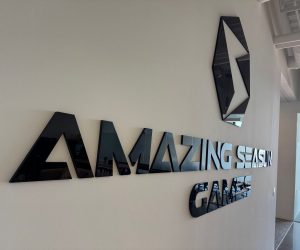 Glossy black acrylic 3D wall letters and logo mounted on a white office wall in Corona, CA.